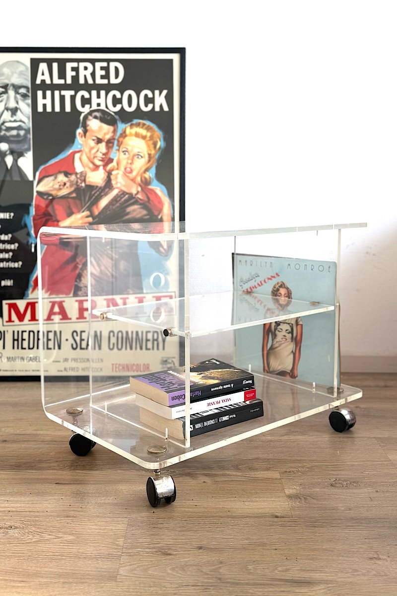 Table basse en plexiglas sur roulettes, photo de présentation avec des livres et vinyles