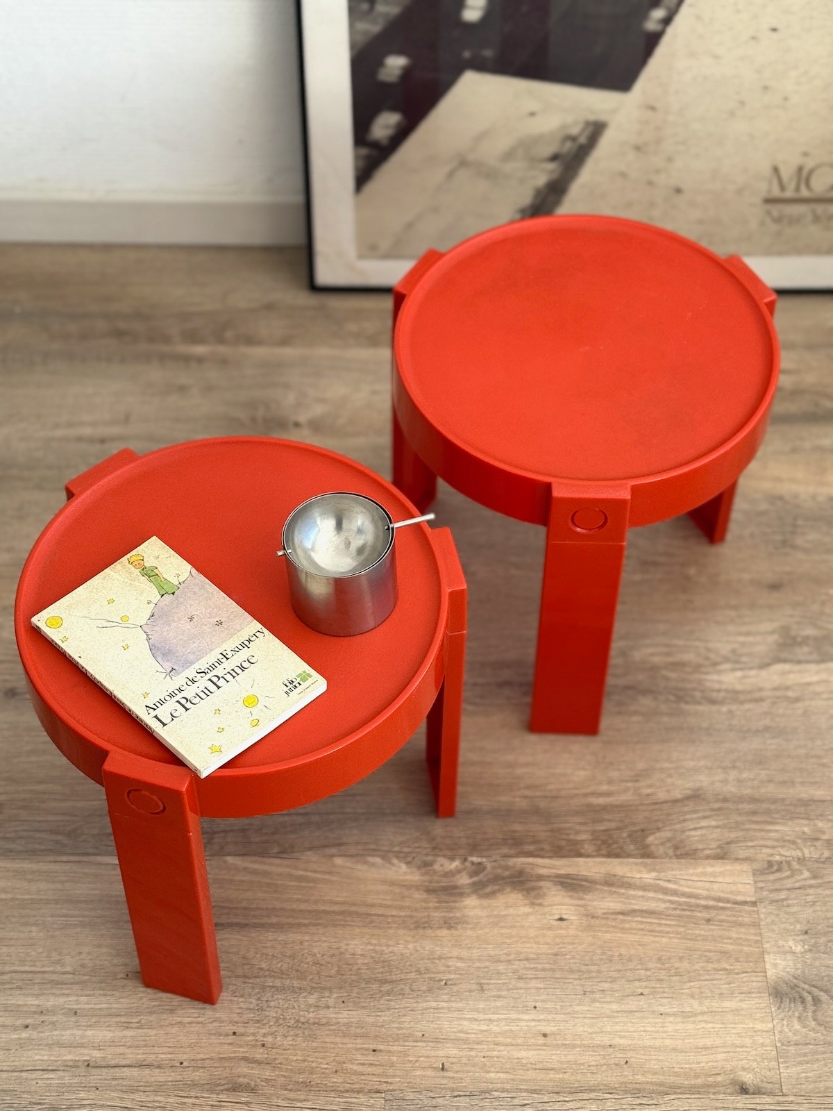 Tables basses Prisunic en plastique rouge, années 70. Vue de dessus avec un livre et un cendrier dessus
