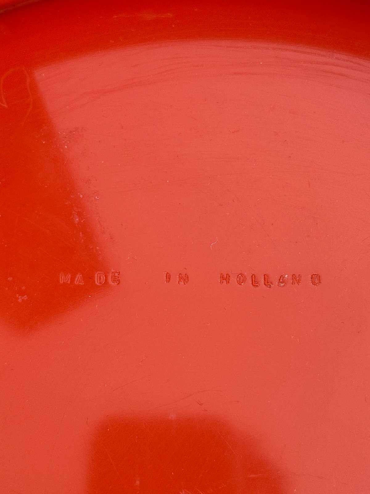 Vue de l'estampille sous le plateau d'une table en plastique rouge Prisunic années 70
