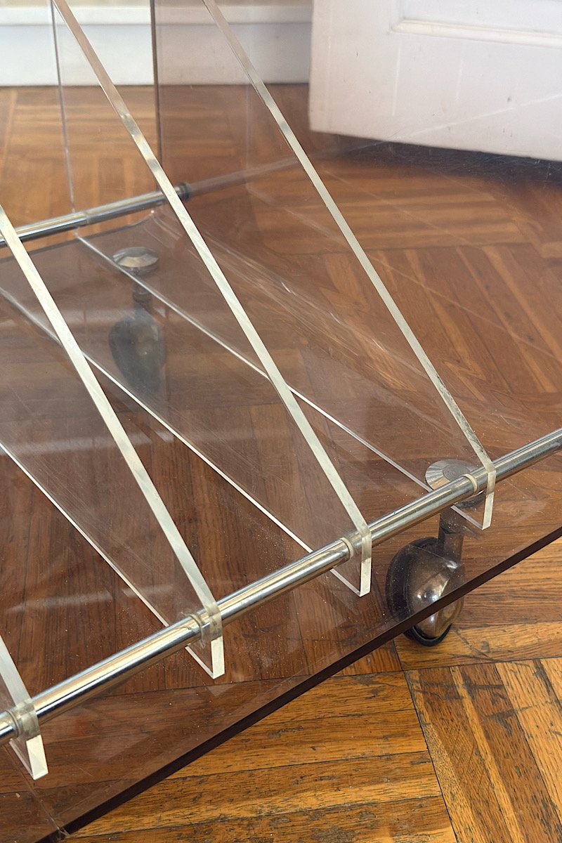 Structure en plexiglas transparent d'une table à vinyles sur roulettes, montrant les séparateurs et le parquet en arrière-plan.