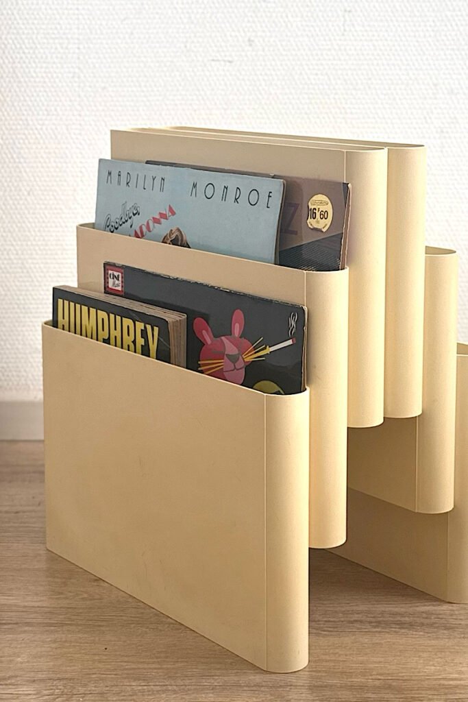 Porte-revues Giotto Stoppino pour Kartell modèle 4675 beige avec magazines.