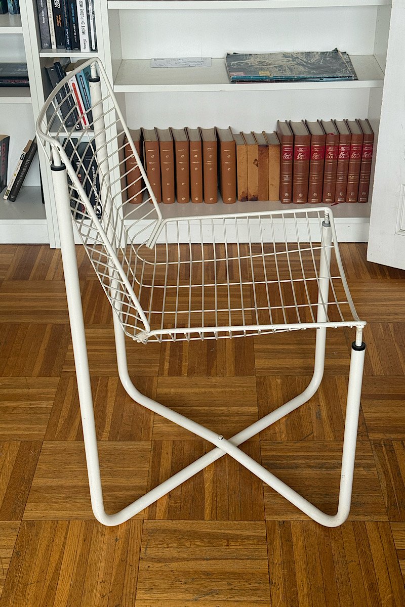 Vue de profil d'une chaise design vintage en fil de métal blanc, modèle iconique créé par Niels Gammelgaard pour IKEA dans les années 80