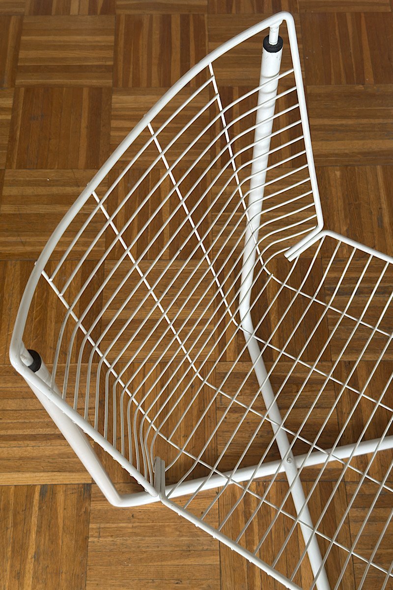 Gros plan sur le dossier en fil de métal blanc d'une chaise design vintage, modèle iconique créé par Niels Gammelgaard pour IKEA dans les années 80.