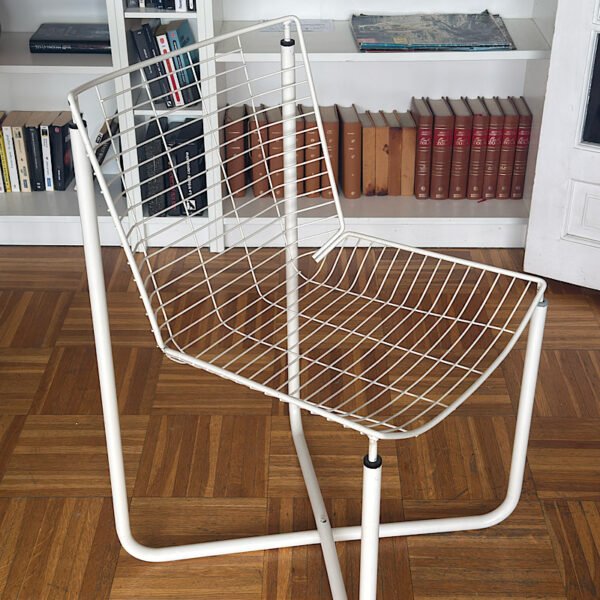 Vue plongeante sur une chaise design vintage en fil de métal blanc, modèle iconique créé par Niels Gammelgaard pour IKEA dans les années 80.