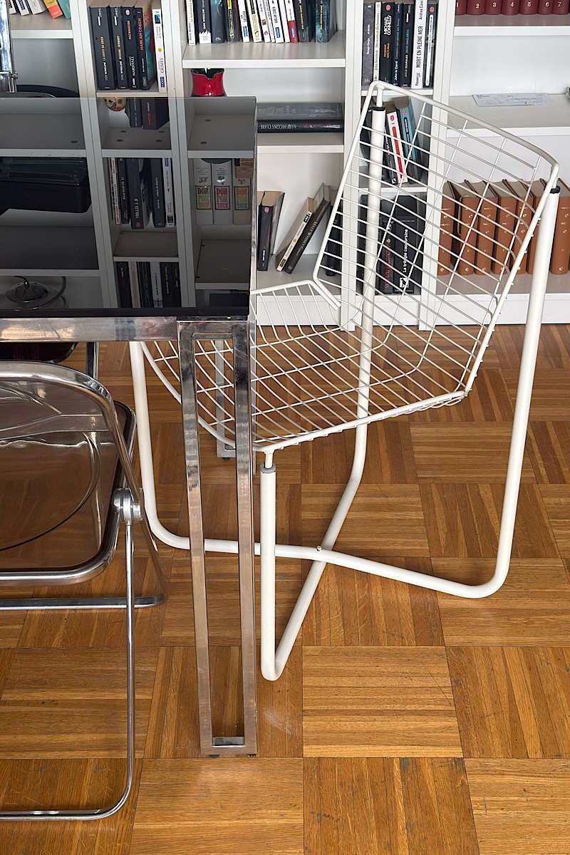 Chaise design vintage en fil de métal blanc, modèle IKEA des années 80 par Niels Gammelgaard, vue en situation dans un intérieur avec parquet.