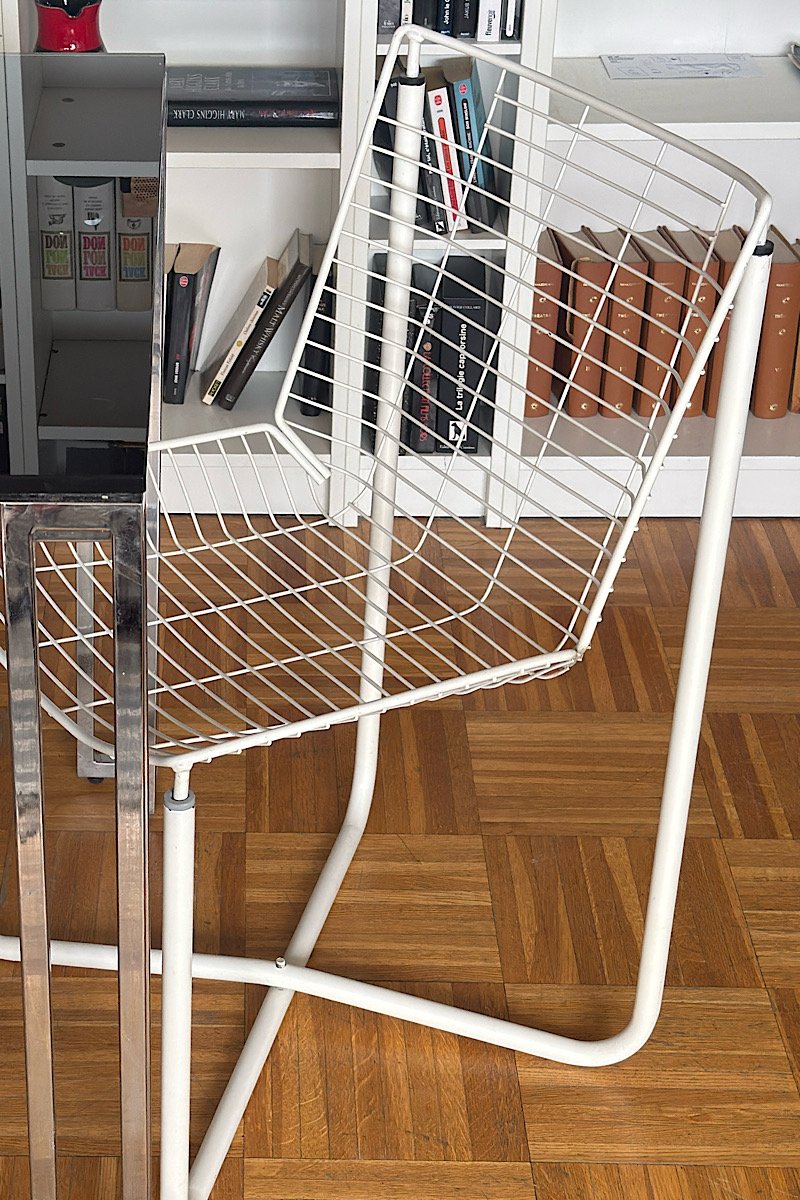Vue de trois-quarts d'une chaise vintage en fil de fer blanc, modèle iconique signé Niels Gammelgaard pour IKEA dans les années 80.