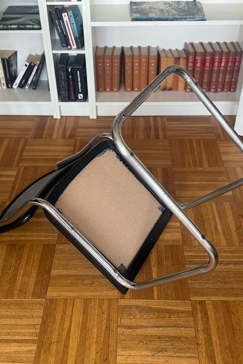 Vue de la chaise Cesca B32 couchée sur le côté, montrant le dessous de l'assise et la structure en porte-à-faux en tube d'acier chromé