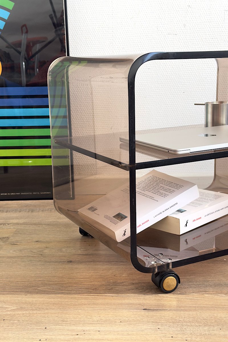 Table basse en plexiglas fumé sur roulettes, vue de profil