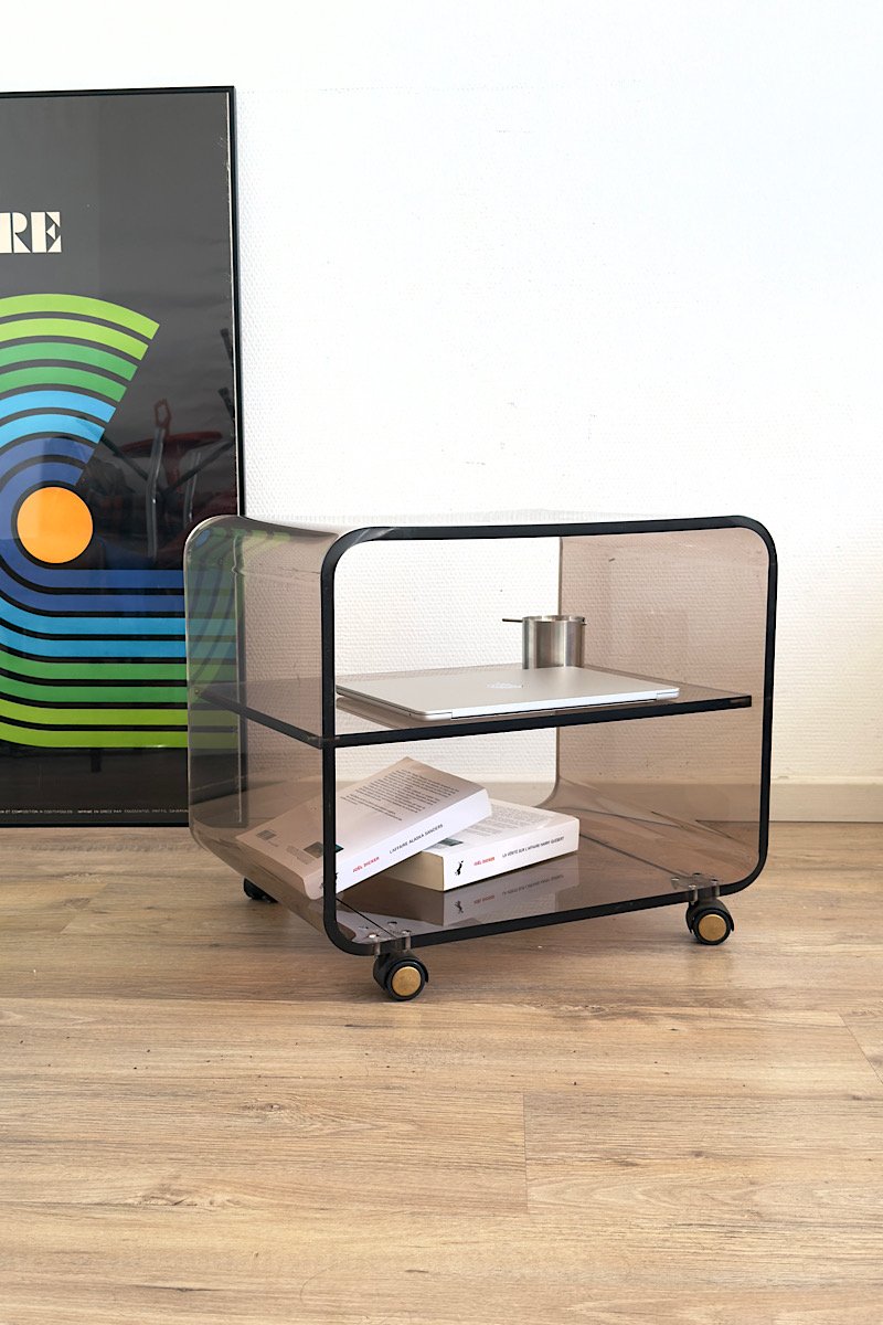 Table basse en plexiglas fumé sur roulettes, vue de trois quart