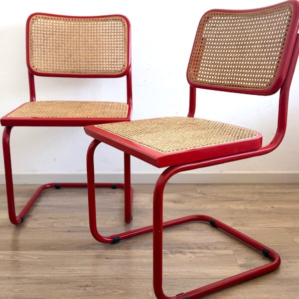 Paire de chaises Cesca B32 rouges avec structure en acier tubulaire et assise en cannage, vue de présentation générale