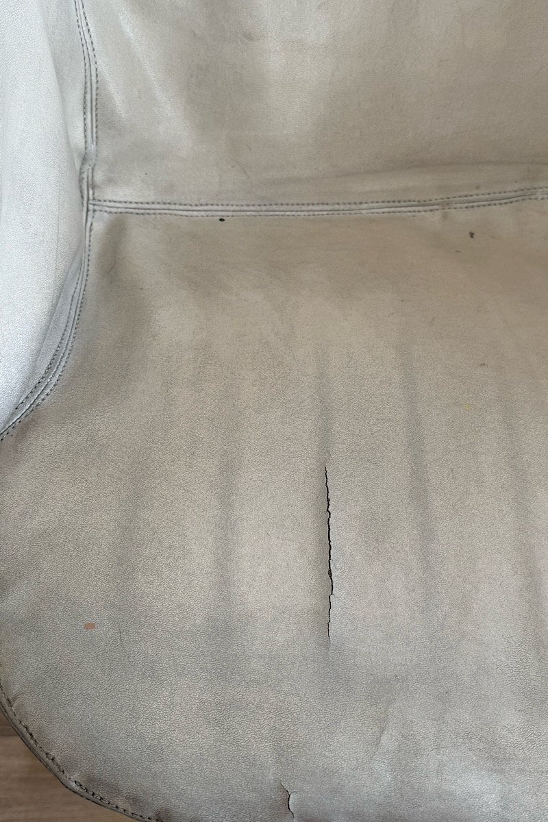 Gros plan sur le cuir crème texturé de l'assise du fauteuil Flynn par Gastone Rinaldi