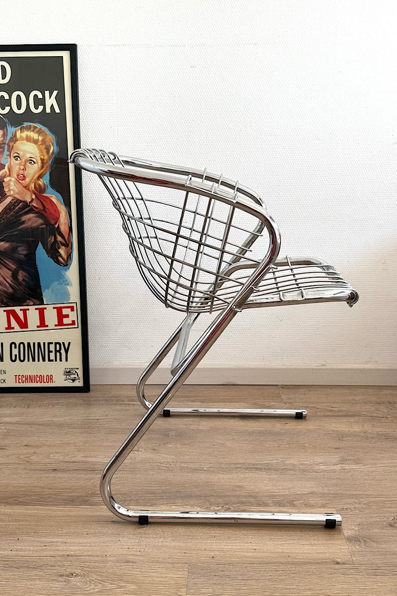 Fauteuil Flynn de Gastone Rinaldi avec structure filaire en métal chromé et assise en cuir crème. Vue latérale dans un intérieur